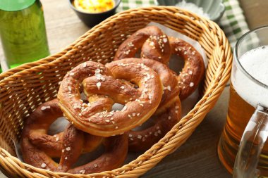 Sepette lezzetli krakerler ve ahşap masada bira, yakın plan.