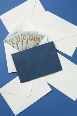 Para bonusu. Mavi zemin üzerinde dolar banknotları olan zarflar, düz yatıyordu.