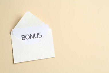 Bonus yazan kart ve bej arka planda zarf, üst manzara. Metin için boşluk