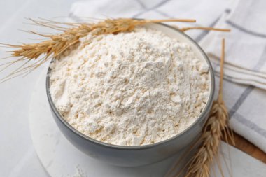 Buğday unu ve çiviler beyaz masada, yakın plan.