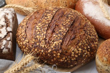 Taze ekmek somunları ve çiviler beyaz masada, yakın plan.