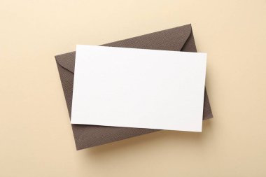 Bej arkaplanda boş davetiye ve zarf, üst görünüm
