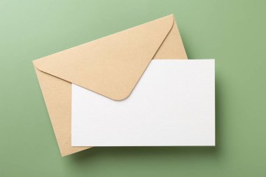 Açık yeşil arkaplanda boş davetiye ve zarf, üst görünüm