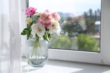 Pencere pervazında vazoda bir buket güzel şakayık, metin için yer var.