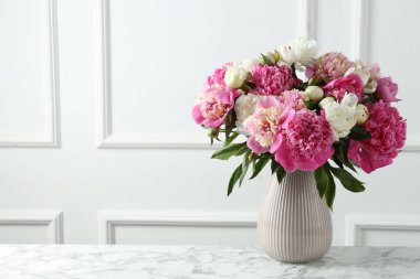 Beyaz mermer masada vazodaki bir buket güzel şakayık.