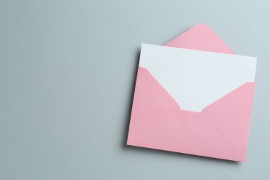 Gri arka planda boş davetiye ve zarf, üst manzara. Metin için boşluk