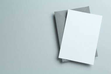 Gri arka planda boş davetiye ve zarf, üst manzara. Tasarım için boşluk