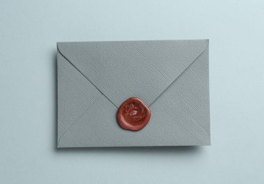 Gri arkaplanda balmumu mühürü olan güzel bir davetiye zarfı, üst görünüm