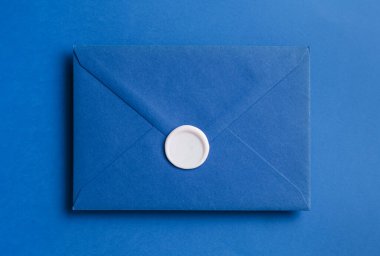 Mavi arkaplanda balmumu mühürü olan güzel bir davetiye zarfı, üst görünüm