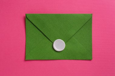 Pembe arka planda balmumu mühürü olan güzel bir davetiye zarfı, üst görünüm