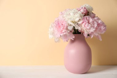 Beyaz masadaki vazodaki güzel şakayıklar bej arka planda. Metin için boşluk