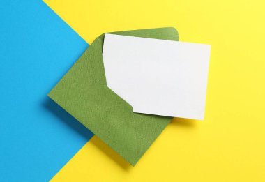 Renk arkaplan üzerinde boş davetiye ve zarf, üst görünüm. Tasarım için boşluk