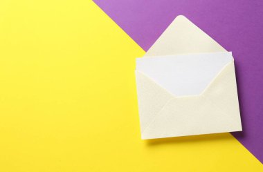 Renk arkaplanı üzerine boş davet kartı ve zarf, üst görünüm