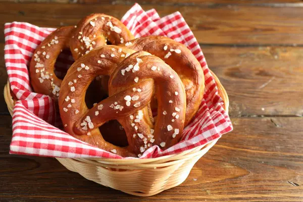 Hasır sepetteki tuzlu krakerler ahşap masada, yakın plan. Metin için boşluk