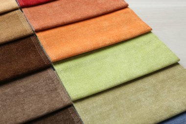 Açık ahşap masadaki farklı kumaşlardan örnekler.