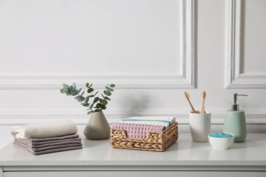 Temiz waffle havluları ve diğer banyo ürünleri banyodaki beyaz şifoniyerde.