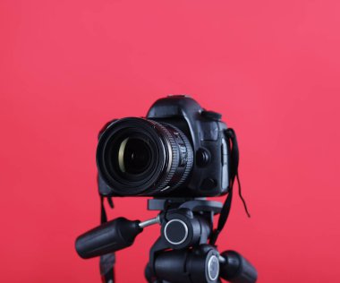 Kırmızı arkaplanda modern profesyonel video kamera, yakın plan