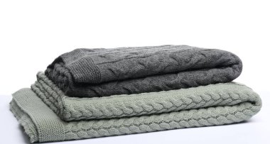 Beyaz arkaplanda iki katlanmış yün battaniye.