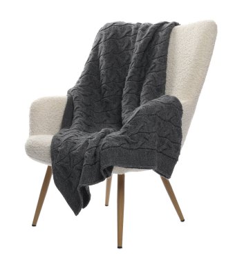 Beyaz üzerinde battaniyesi olan rahat bir koltuk.