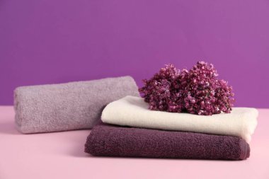 Renkli arka planda yumuşak havlular ve leylak çiçekleri