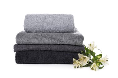 Havlu yığını ve beyaz üzerine izole edilmiş güzel çiçekler.