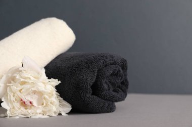 Yumuşak havlular ve gri arka planda şakayık çiçekleri, yakın plan. Metin için boşluk