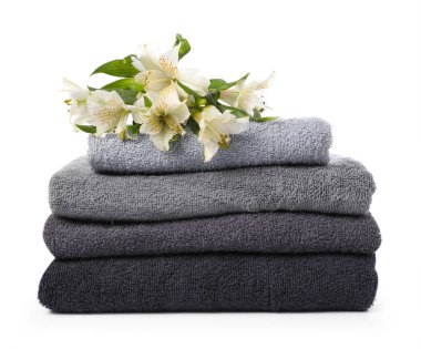 Yumuşak havlu yığını ve beyaz zambaklar.