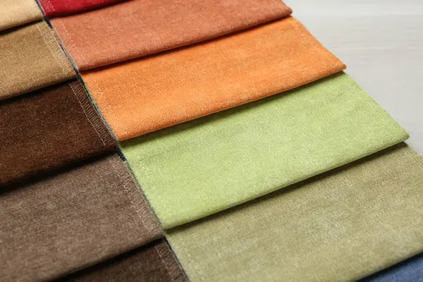 Açık ahşap masadaki farklı kumaşlardan örnekler.