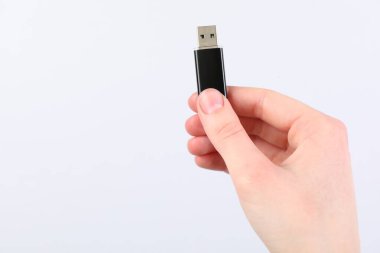 Açık gri arka planda modern flash diski olan adam, yakın plan. Metin için boşluk