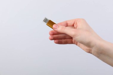 Açık gri arka planda modern flash diski olan adam, yakın plan. Metin için boşluk