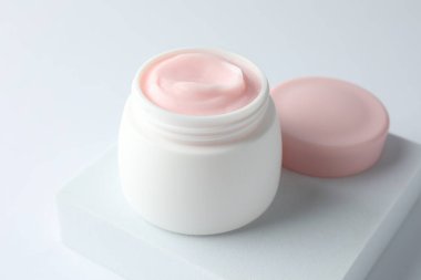 Beyaz arka planda nemlendirici krem kavanozu, yakın plan.