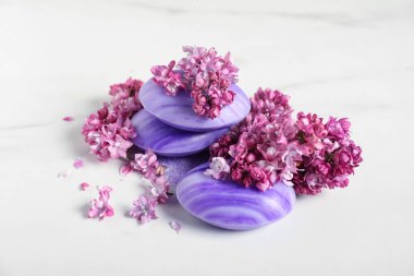 Sabun çubukları ve leylak çiçekleri beyaz masada, yakın plan.