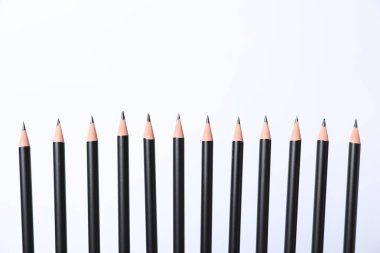 Beyaz arka planda bir sürü keskin grafit kalem var. Metin için boşluk