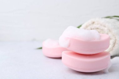 Beyaz masadaki köpüklü sabun çubukları, yakın plan. Metin için boşluk