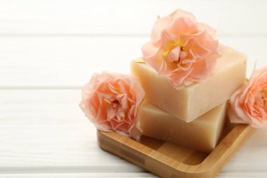 Sabun çubukları ve beyaz ahşap masada güzel çiçekler, yakın plan. Metin için boşluk