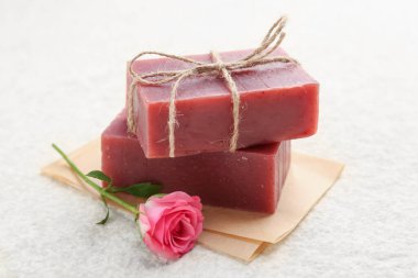 Sabun çubukları ve bej masadaki güzel gül, yakın plan.