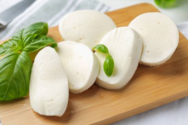 Nefis mozzarella peyniri ve fesleğen yaprakları masanın üzerinde, yakın plan.