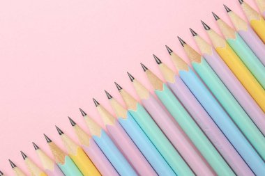 Pembe arka planda bir sürü grafit kalem var. Metin için boşluk