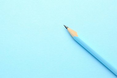 Açık mavi arka planda bir grafit kalem, üst manzara. Metin için boşluk