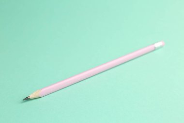 Turkuaz arka planda silgisi olan bir grafit kalem, yakın plan.