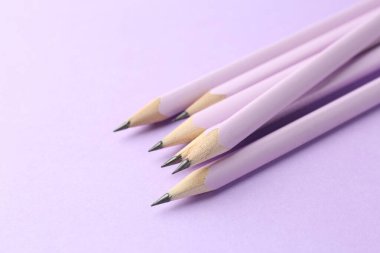 Menekşe arkaplanda birçok grafit kalem var, yakın plan. Metin için boşluk