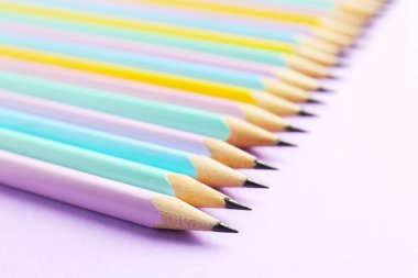 Menekşe arkaplanda birçok grafit kalem var, yakın plan. Metin için boşluk