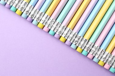 Menekşe arkaplanda silgisi olan bir sürü grafit kalem. Metin için boşluk