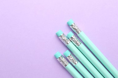 Menekşe arkaplanda silgisi olan bir sürü grafit kalem. Metin için boşluk