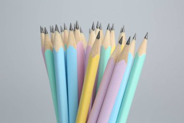 Açık gri arkaplanda birçok grafit kalem, yakın plan