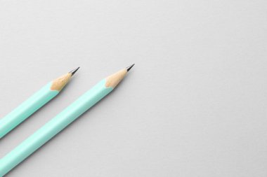 Açık gri zemin üzerinde iki grafit kalem, düz zemin. Metin için boşluk