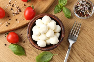 Lezzetli mozzarella topları, domatesler, biberler ve fesleğenler ahşap masada, düz yatıyordu.