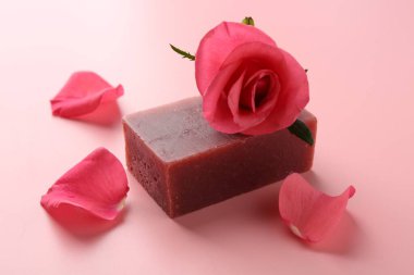 Sabun barı ve pembe arka planda güzel bir gül, yakın plan.