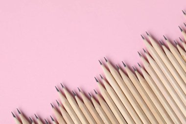 Pembe arka planda bir sürü grafit kalem var. Metin için boşluk