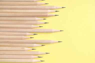 Sarı arka planda bir sürü grafit kalem var. Metin için boşluk